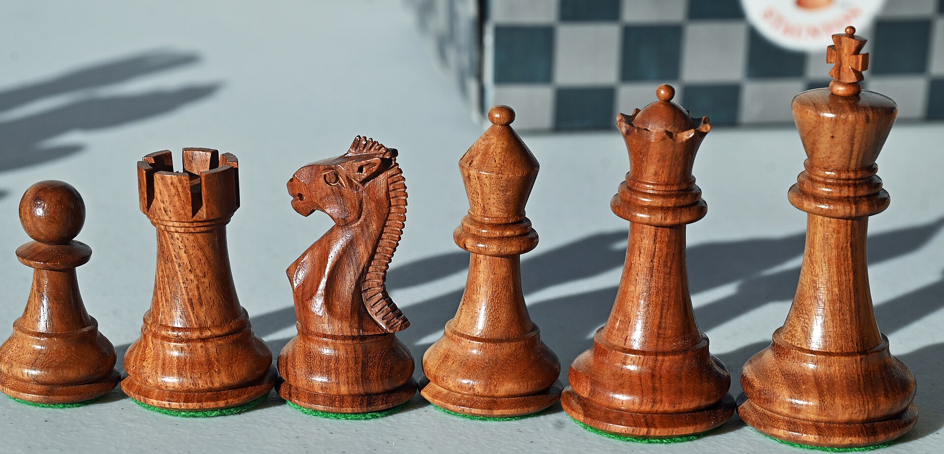 A walnut chess set staged on felt
